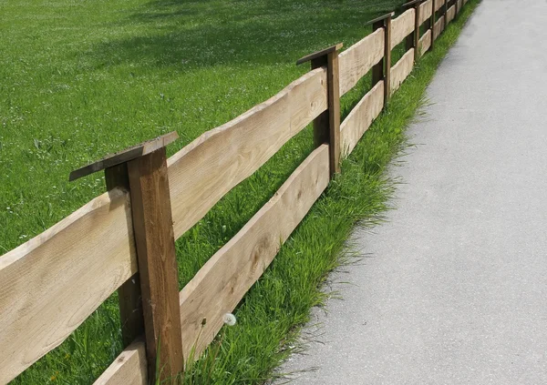 Wooden fence and green meadow, diagonally — Stock Photo, Image