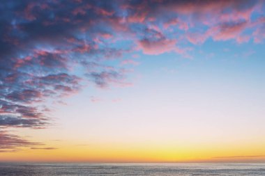 Atlantik Okyanusu, pembe bulutlu mavi gökyüzü ve ortasındaki fotokopi alanı.