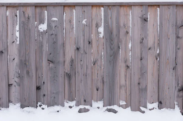 雪の山の中の木製フェンス素朴な松の板冬の季節の背景 — ストック写真