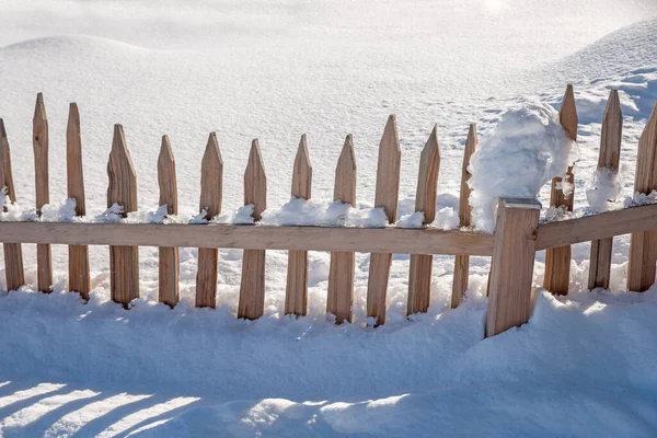 新しい落下粉末雪の中の木製格子フェンス 冬の背景 — ストック写真