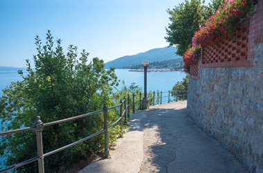 Hırvatistan kıyısında Opatija yakınlarında güzel bir sahil geçidi. Duvarın üzerinde sardunyalar asılı.