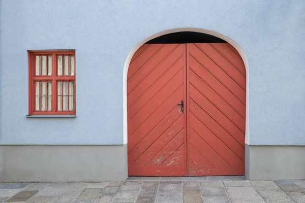 ライトブルー塗装家の前 赤アーチ型の木製のドアと格子窓 コピースペースのある建築的背景 — ストック写真