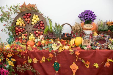 Meyveli, sebzeli, sonbahar yapraklı ve çiçekli dekoratif şükran günü masası. elmalı tekerlek