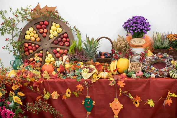 Meyveli, sebzeli, sonbahar yapraklı ve çiçekli dekoratif şükran günü masası. elmalı tekerlek