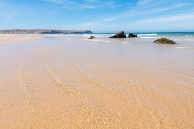 wide sandy beach with shallow water from incoming waves, coastal landscape Portugal west algarve near Carrapateira