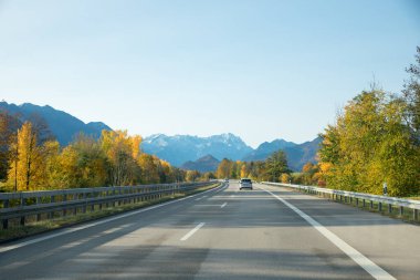 Garmisch-Partenkirchen otoyolu ve sonbahar manzarasında Bavyera Alpleri. Boşluğu kopyalayan mavi gökyüzü