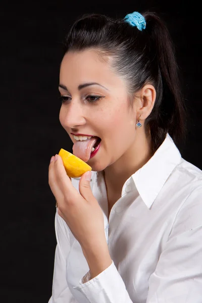 Γυναίκα φάνε κίτρινο λεμόνι — Φωτογραφία Αρχείου