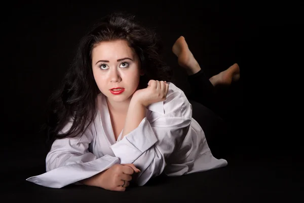 Retrato de mulher de cabelos longos em camisa masculina deitada em uma ba preta — Fotografia de Stock