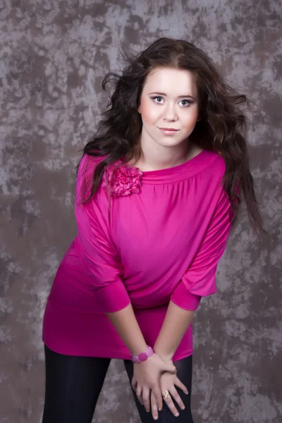 Ragazza con i capelli lunghi in una camicetta rosa — Foto Stock