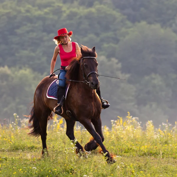 Donna in cappello rosso equitazione — Foto Stock