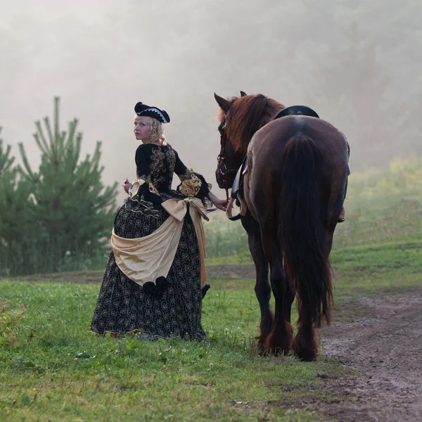 Femme en robe royale baroque équitation — Photo