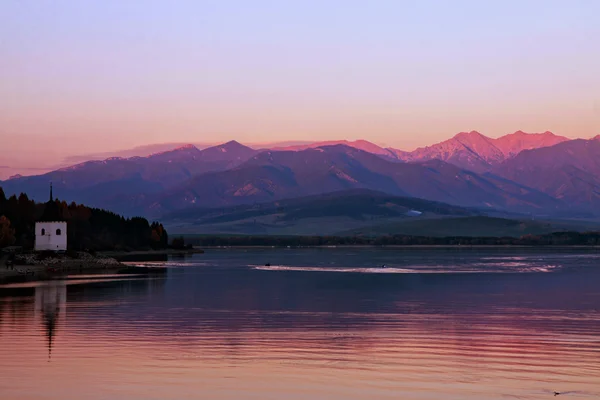 Lac avec une chapelle au coucher du soleil — Photo