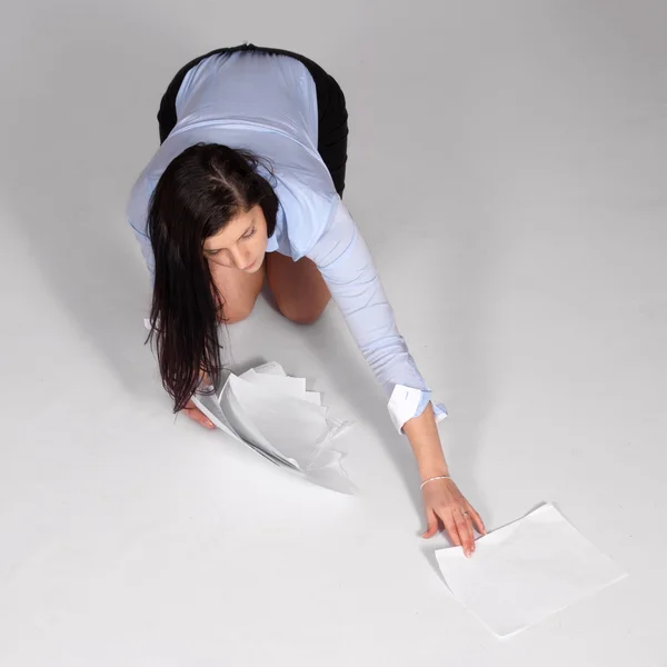 Young woman raised fallen documents — Stock Photo, Image