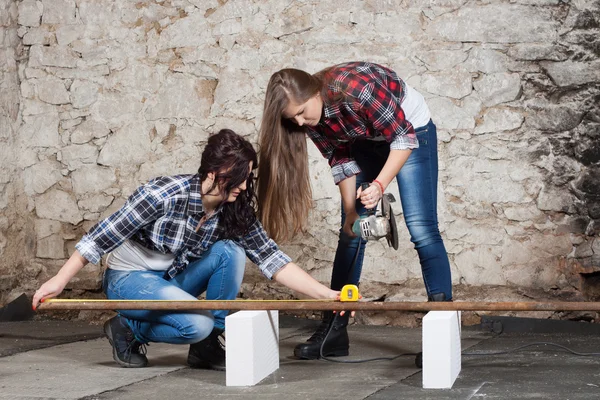 Two long-haired young woman with an angle grinder — Stock Photo, Image