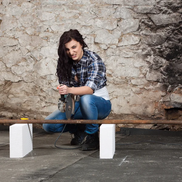 Young long-haired woman with an angle grinder — Stock Photo, Image