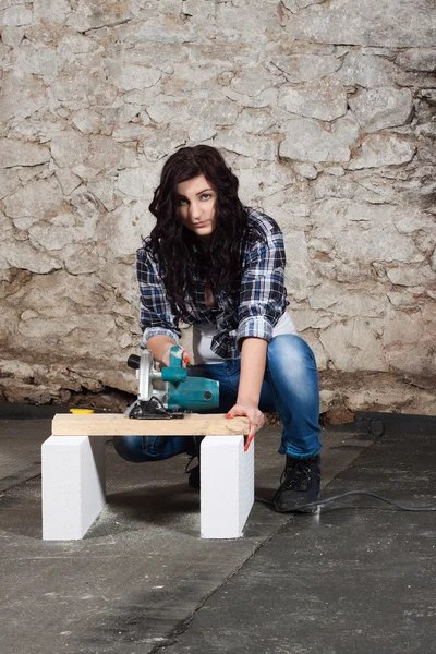 Young long-haired woman with a circular saw — Stock Photo, Image