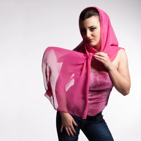 Young woman in pink corset, jeans, high heels with pink scarf — Stock Photo, Image