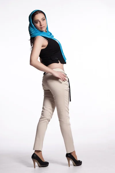 Giovane donna in pantaloni beige, gilet nero con sciarpa blu — Foto Stock