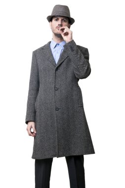 gri paltolu ve gri bir şapka giymiş bir insan