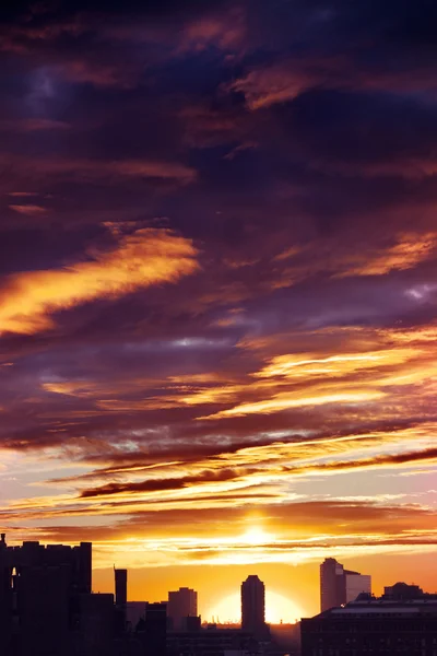 Bewolkt zonsondergang over stedelijke skyline van silhouet — Stockfoto