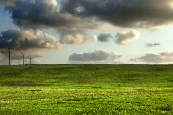 Met gras begroeide heuvels onder dramatische hemel — Stockfoto