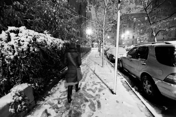 Lone woman walking on the snow covered pavement of a Harlem stre — Stock Photo, Image