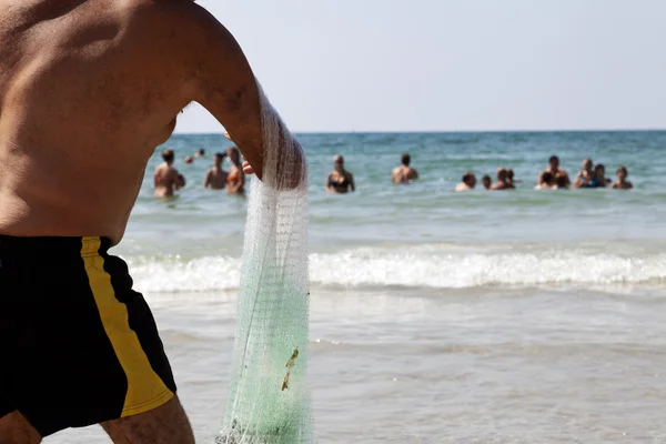 Pescador tirando de la red en la playa de Tel-Aviv — Foto de Stock
