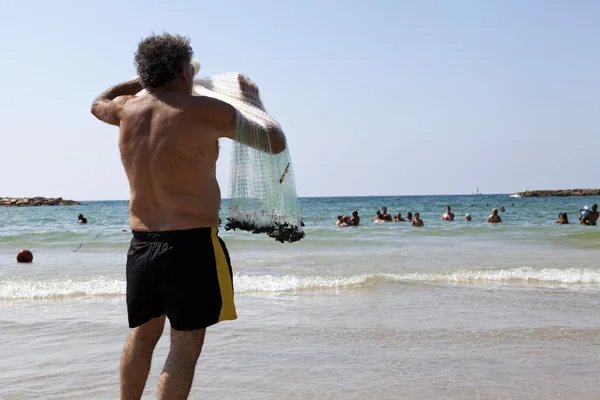 Pescador tirando de la red en la playa de Tel-Aviv — Foto de Stock