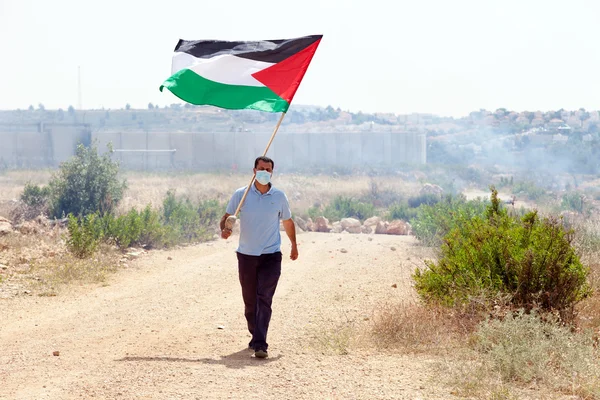 Палестинский протестующий держит флаг у стены разделения Западная Ба — стоковое фото