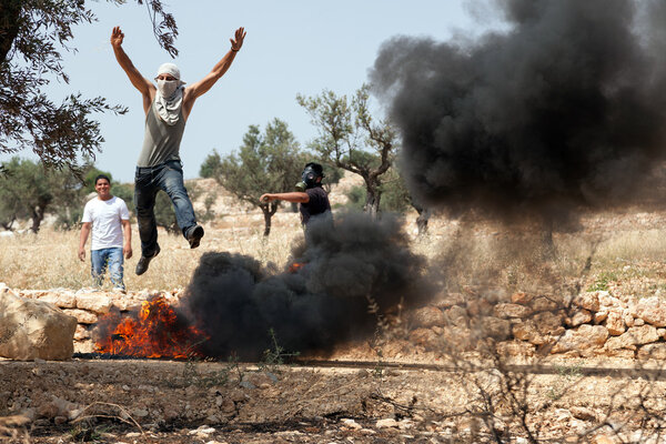 Palestinian Man Jumping over Fire at Protest