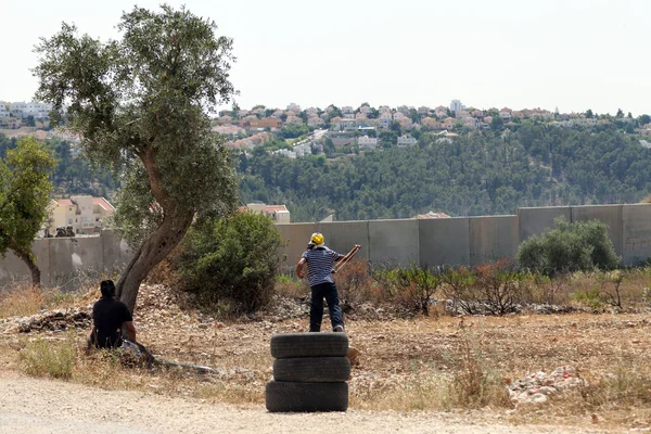 Un manifestant palestinien tire sur un rocher lors d'une manifestation — Photo