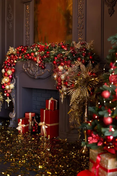 Christmas fireplace decorated with balls and lights in luxury interior close up — Stock Photo, Image