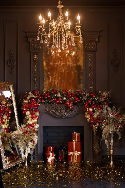 Christmas fireplace decorated with balls and lights in luxury interior close up — Stock Photo, Image