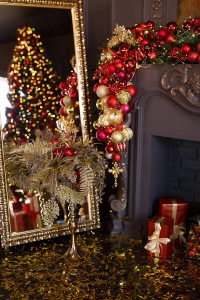 Christmas fireplace decorated with balls and lights in luxury interior close up — Stock Photo, Image