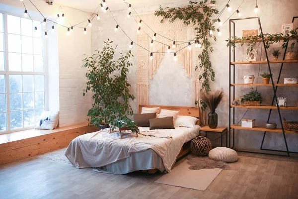 Gemütlicher Schlafzimmerbereich im Luxus-Studio-Apartment mit kostenlosem Layout im Loft-Stil mit großem Panoramafenster und grüner Bepflanzung. — Stockfoto