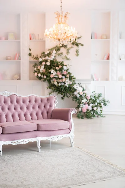 Luxe rijke woonkamer interieur met elegante klassieke meubels versierd met bloemen. Grote licht witte kamer met groot raam en open haard. — Stockfoto