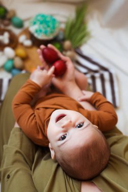 Mutlu Paskalyalar. Evde paskalya yumurtası ve pastayla oynayan sevimli ve mutlu bir bebek..