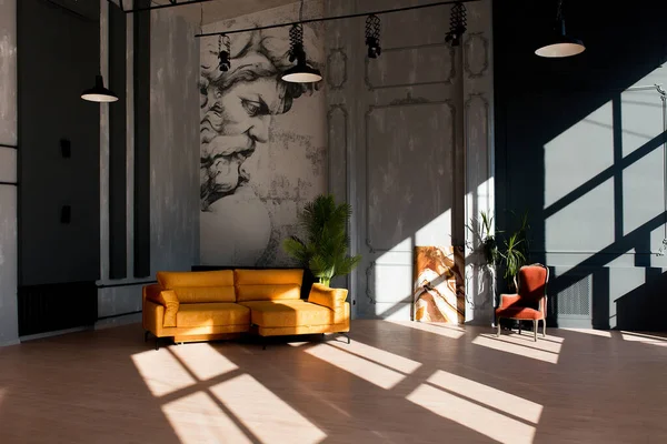 Moderne loft woonkamer met hoog plafond, zwarte en grijze muren, houten vloer, design meubels en tropische planten. — Stockfoto