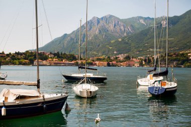 İtalya 'nın Como Gölü' ndeki eski bir kasabanın limanında yelken açan yatlar..