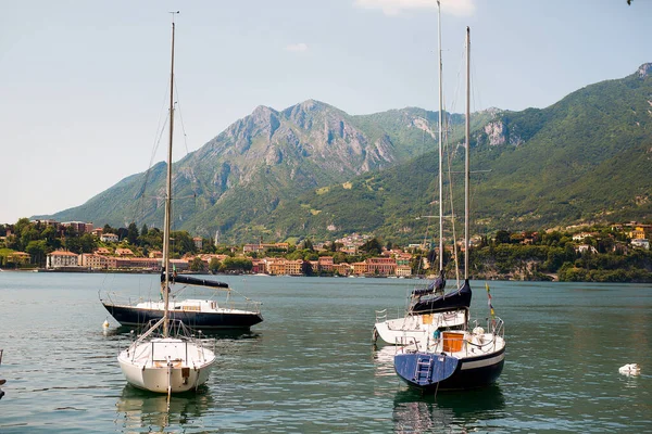 İtalya 'nın Como Gölü' ndeki eski bir kasabanın limanında yelken açan yatlar..