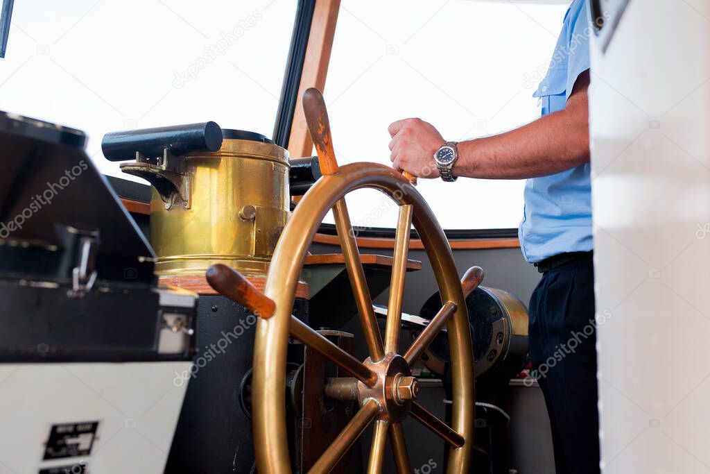 Close view into captains cabins, navigation equipment hand of captain on ships helm during cruising.