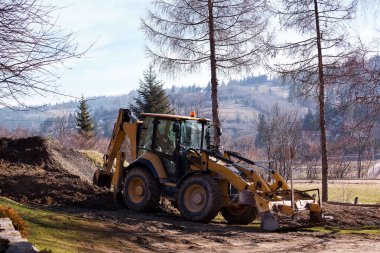 Tekerlek kazıcı yükleyici inşaat alanındaki toprağı kazıyor..