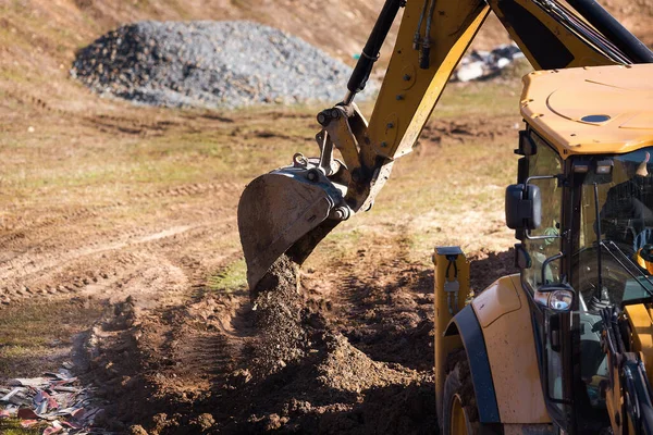 Cargador excavadora de ruedas está cavando el suelo en el sitio de construcción. — Foto de Stock