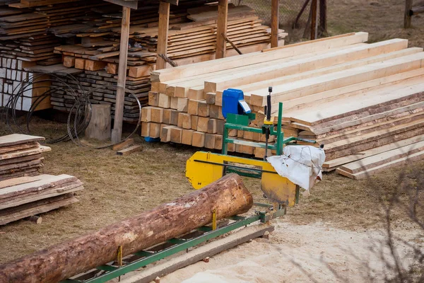 제재소. 장비 제재소에서 통나무를 가공하는 과정. 기계가 널빤지 위에서 나무줄기를 톱질하는걸봤어요. 목재를 다듬는 나무 톱밥 작업. — 스톡 사진