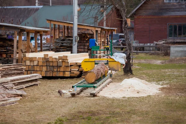 Sawmill. Process of machining logs in equipment sawmill. Machine saw saws the tree trunk on the plank boards. Wood sawdust work sawing timber wood. Selective focus — Stock Photo, Image