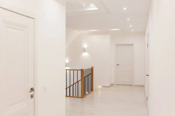 Nowoczesne wnętrze domu z białymi ścianami i drzwiami oraz drewnianymi schodami — Zdjęcie stockowe