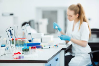 Pipette test tüpüne örnek bırakıyor. Laboratuvar asistanı laboratuvarda kan tahlili yapıyor. DNA analizi.