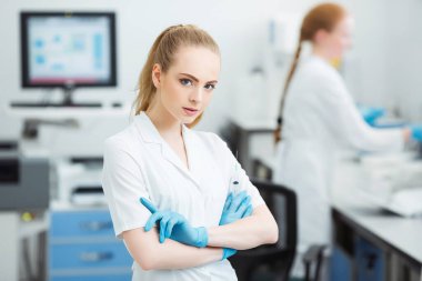 Ellerinde tıbbi şırınga olan profesyonel bir doktor modern laboratuarda enjeksiyona hazırlanıyor..