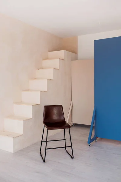 Brown chair over wall with stairs in the hipster interior modern room