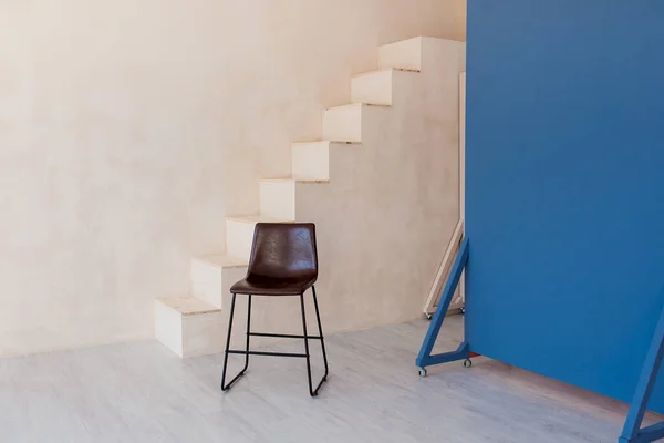 Brown chair over wall with stairs in the hipster interior modern room